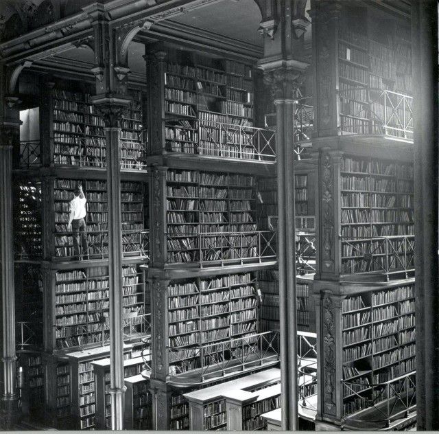 Mężczyzna zdejmuje książkę z p&oacute;łki w Bibliotece Gł&oacute;wnej w Cincinnati. USA, 1874.