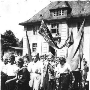 1950 rok. Święto Pracy. Uczniowie szkoły podstawowej w Mysłakowicach. Obok budynek starej (poniemieckiej) szkoły. 