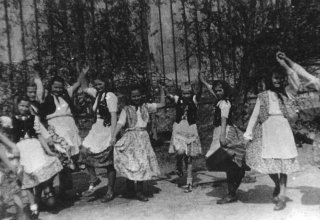 Dzieci tańczą przed szkolą w Mysłakowicach 1952 rok. 