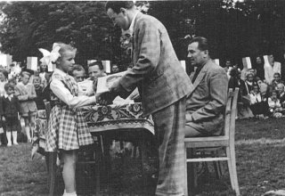 Mysłakowice, szkoła. Przewodniczący Komitetu Rodzicielskiego Pan Marukiewicz wręcza nagrodę Bożenie Mruklik. 1958 r.